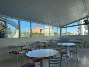 a row of tables and chairs in a room with a view at Pousada Bella Vista in Aparecida