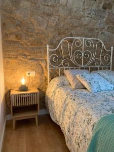 1 dormitorio con 1 cama con lámpara en una mesita de noche en Casa A praciña, Playa de Soesto en Laxe