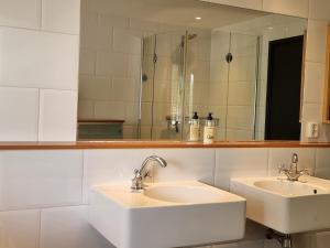 エンクホイゼンにあるAan de Burgwalのバスルーム(洗面台2台、鏡付)