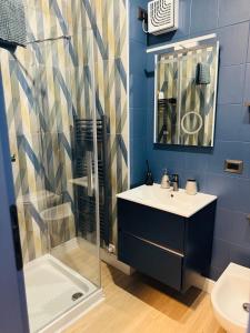 a blue bathroom with a sink and a shower at Casa VikToria in Pordenone