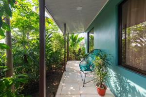 eine Terrasse mit einem blauen Haus mit einem Stuhl und Pflanzen in der Unterkunft Vacation Home Bartenderluisch in Fortuna