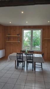 a dining room with a table and chairs and a window at Les Grands Riez - logement à la campagne 