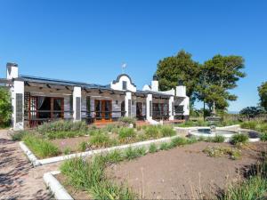 a building with a garden in front of it at Dunkes Organic Equestrian Estate in George