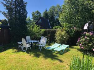 een groep stoelen en een tafel in een tuin bij Eifelhäuschen in Blankenheim