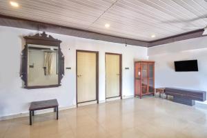 a large room with a mirror and a television at GOA Down D Vilage Prime in Candolim