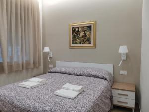 1 dormitorio con 1 cama con 2 toallas en Palazzo Buscema - Casa & Vacanza, en Crotone