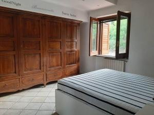 a bedroom with a bed and wooden cabinets and a window at Casa del sole in Ioppolo