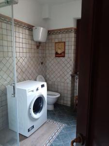 a washing machine in a bathroom with a toilet at Casa del sole in Ioppolo +3 photos