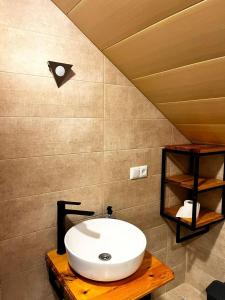a bathroom with a white sink on a wooden table at Nino & Irodi's Guest House in Kutaisi