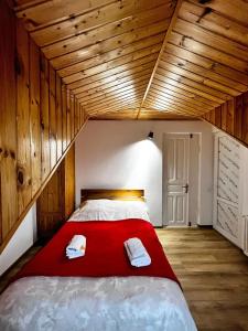 a bedroom with a red bed with two towels on it at Nino & Irodi's Guest House in Kutaisi