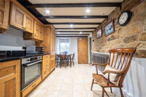 a kitchen with a chair and a clock on the wall at Host & Stay - Well Farm Cottage in Higham +16 photos