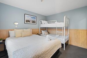 a bedroom with two bunk beds and a bed with a bunk bedskirts at Tasman Holiday Parks - Christchurch in Christchurch