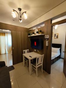 a living room with a table and a bed at Coast Residences by Haven Selah in Manila