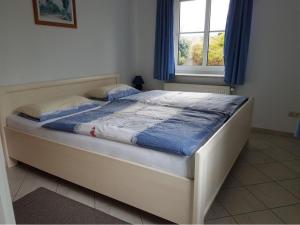- un lit dans une chambre avec fenêtre dans l'établissement Gepflegte Ferienwohnung Rugenbarg, à Heiligenhafen