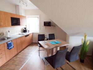 cocina con mesa y sillas en una habitación en Komfortable Ferienwohnung mit Seeblick - b56594, en Bad Arolsen