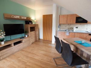 uma cozinha e sala de jantar com uma mesa e uma televisão em Komfortable Ferienwohnung mit Seeblick - b56594 em Bad Arolsen