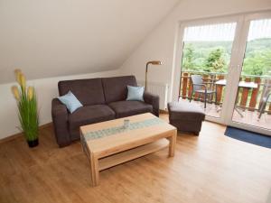 uma sala de estar com um sofá e uma mesa de centro em Komfortable Ferienwohnung mit Seeblick - b56594 em Bad Arolsen