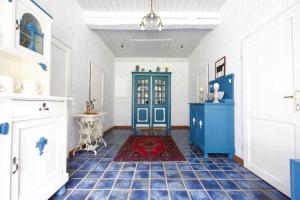 a room with a blue door and a tile floor at Traumhaftes Reetdachhaus an der Nordsee in Süderschweiburg