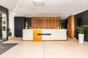 an office lobby with a yellow and white reception desk at Fruške Residences in Vrdnik