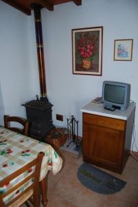 ein Wohnzimmer mit einem TV und einem Herd in der Unterkunft Ferienhaus in Cecina mit Großem Garten in Cecina