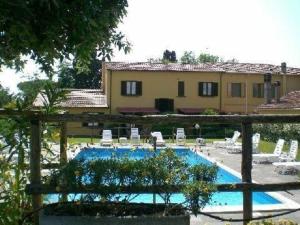 ein Pool mit Stühlen und ein Haus im Hintergrund in der Unterkunft Ferienhaus in Cecina mit Großem Garten in Cecina