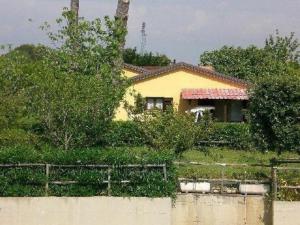 ein gelbes Haus mit einem Zaun davor in der Unterkunft Ferienhaus in Cecina mit Großem Garten in Cecina