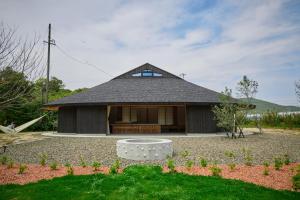 a small house with a black roof at Villa 天ツ星 in Tahara