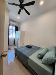 a bedroom with a bed with a ceiling fan at (Female Only) Dungun Town CoLiving Homestay in Dungun