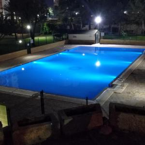una gran piscina azul por la noche en Apartamento Torre San Sebastian Bajo, en Benidorm