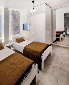 a hotel room with two beds and a couch at Achlia Sea Side Retreat 1 in Ierápetra