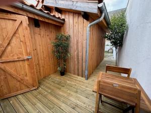 un patio con una valla de madera, una mesa de madera y una silla en Maison avec terrasse & parking Bordeaux Bacalan, en Burdeos