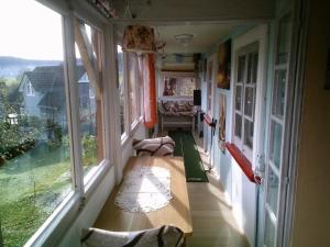 een kamer met een bank op een balkon met ramen bij Appartement in Innerlehen mit Terrasse, Grill und Garten in Bernau im Schwarzwald