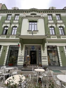 a building with tables and chairs in front of it at FELIX KANITZ Apartments - in the heart of Kapana district in Plovdiv