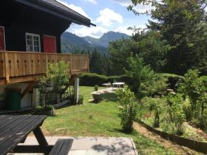 einen Hinterhof mit einem Picknicktisch und einer Terrasse in der Unterkunft Maiensäss WiFi, Naturnah, Familienfreundlich, sonnig, flach, in den Almweiden, guter Preis in Les Paccots