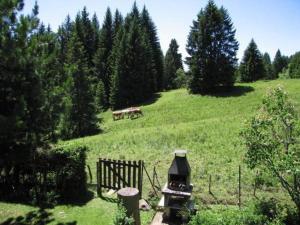 un campo con dos vacas en una colina con árboles en Maiensäss WiFi, Last-Minute, Naturnah, Familienfreundlich, sonnig,in den Almweiden,, en Les Paccots
