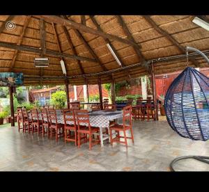 une table à manger et des chaises sous un parasol en bois dans l'établissement Country House, à Viana