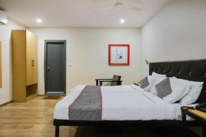 a bedroom with a large bed and a black door at Townhouse 1118 The B&W Motel in Visakhapatnam