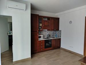 an empty kitchen with wooden cabinets and appliances at Mondello Sea House in Palermo