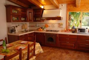 a kitchen with wooden cabinets and a table with a table sidx sidx sidx at Villa Sofia in Terrauzza
