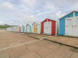 a row of colourful beach huts on the beach at The Wagon Linney in Bude
