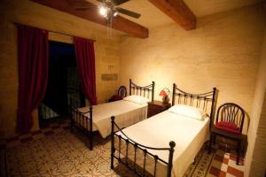 1 dormitorio con 2 camas y ventilador de techo en Villa Tina, en Għarb
