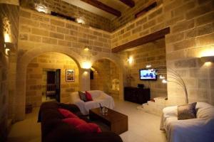 - un salon avec deux canapés et une télévision dans l'établissement Villa Tina, à L-Għarb