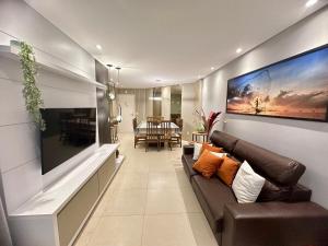 sala de estar con sofá y comedor en Boulevard Bombinhas - Um condomínio Completo que vai te encantar, en Bombinhas