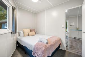 a small bedroom with a bed and a window at Tasman Holiday Parks - Christchurch in Christchurch