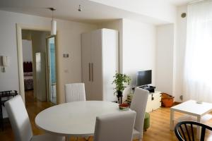 a white dining room with a white table and chairs at Piazza Roma Apartment in Ascoli Piceno