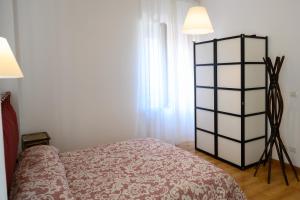 a bedroom with a bed and a lamp next to a window at Piazza Roma Apartment in Ascoli Piceno