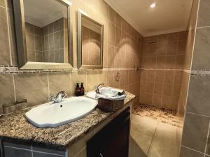 W łazience znajduje się umywalka i lustro. w obiekcie Inkungu Lodge w mieście Champagne Valley