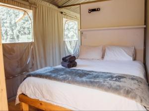 a bedroom with a bed with a camera on it at AfriCamps at Milorho in Rustenburg