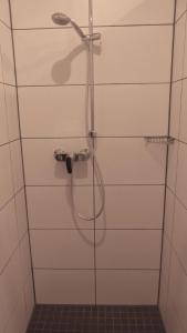 een douche met een slang in de badkamer bij Großzügige Ferienwohnung mit Privatgarten im Nordseebad Carolinensiel in Wittmund