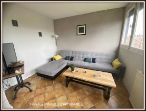 a living room with a couch and a coffee table at Apparemment tout confort in Tarbes